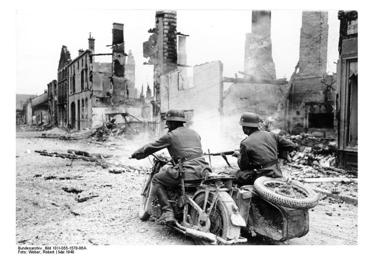 Foto soldater pÃ¥ motorsykkel passerer ruiner i Frankrike